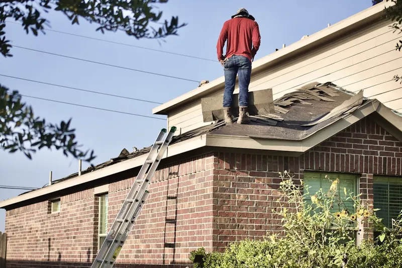 Professional roofer working on a residential roof in Saint John Circle